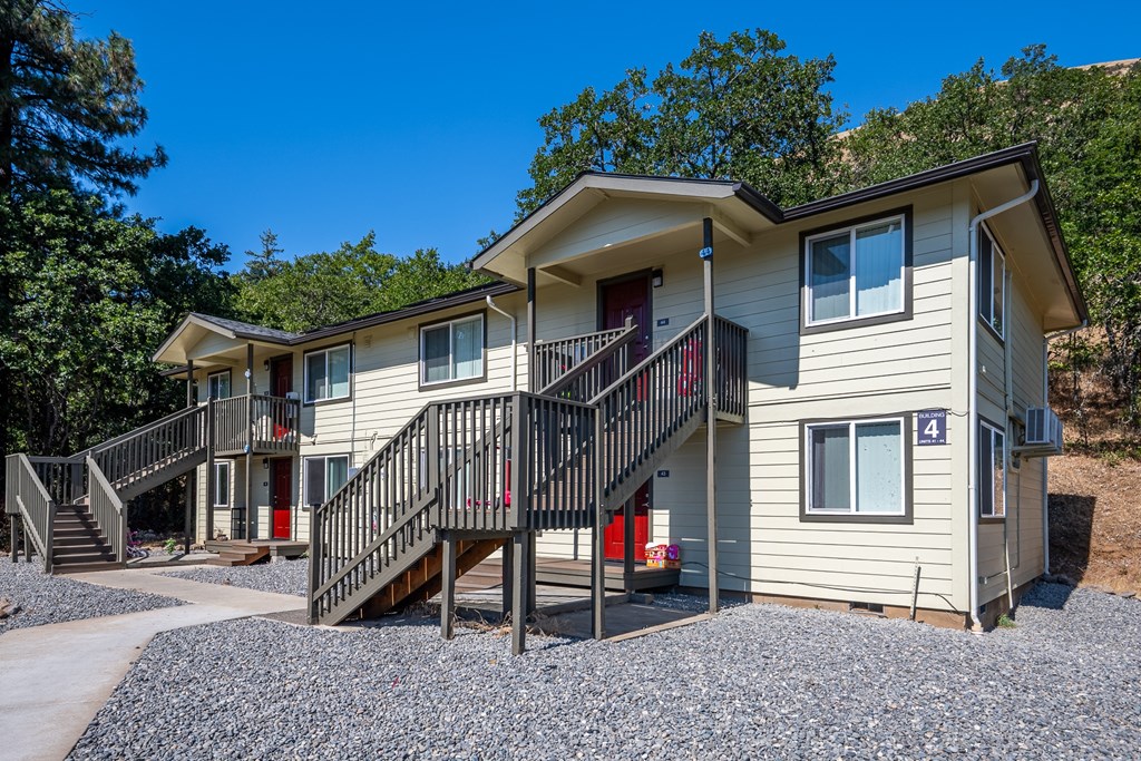 A two-story house with a red door and a balcony.