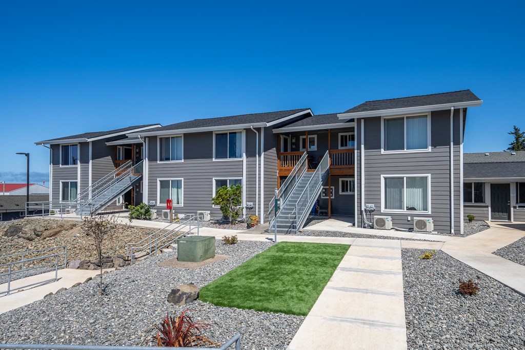 A row of houses with grey siding and white trim.