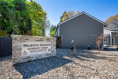 Majestic Gardens Sunburst Manor is a residential building with a sign in front.