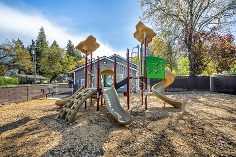 A playground with a yellow slide and a green sign.