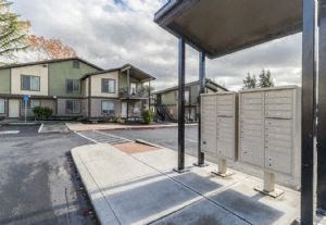an empty parking lot with apartments in the background