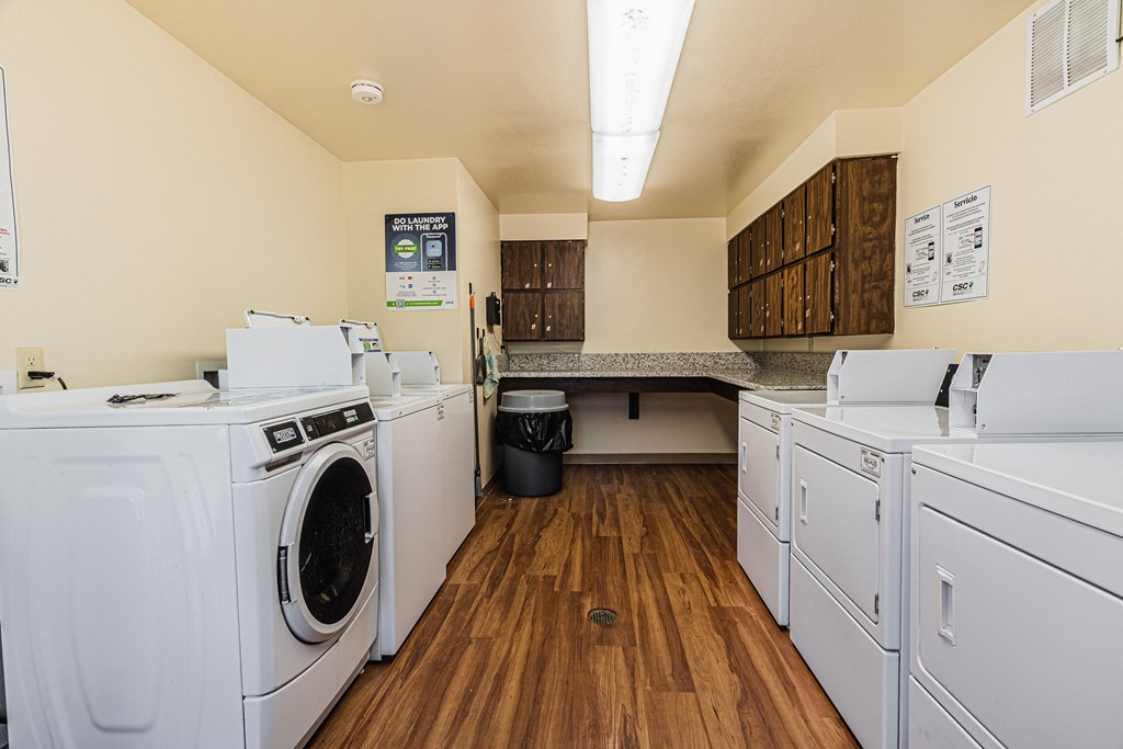 a laundry room with washers and dryers and a counter top with a sink