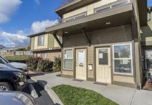 the front of a house with cars parked outside of it