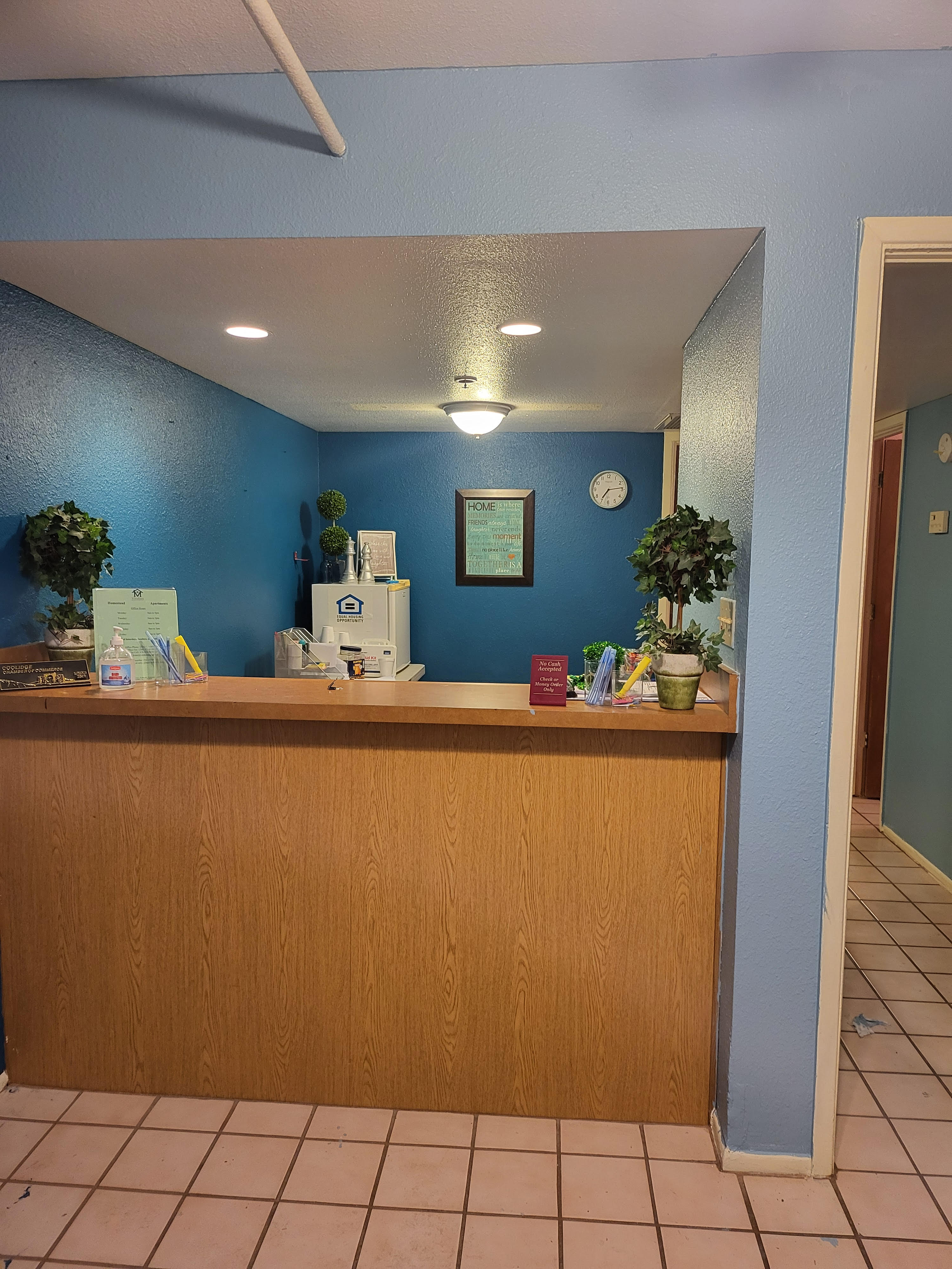 A reception desk with a clock on the wall.