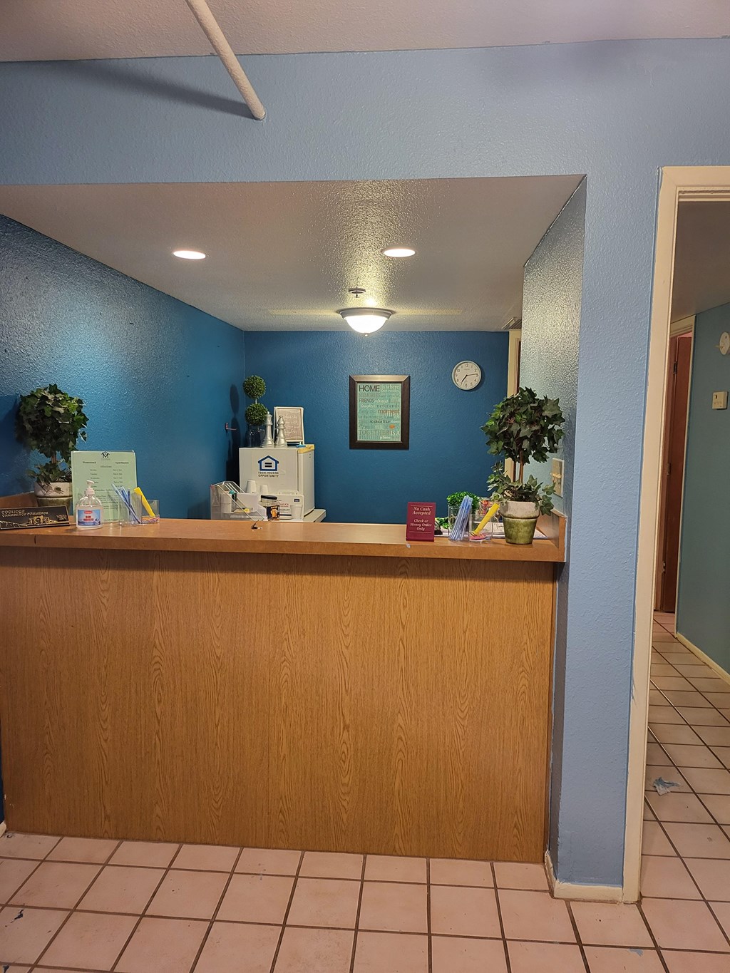 A reception desk with a clock on the wall.