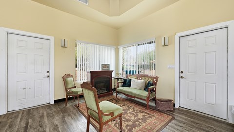 A living room with a fireplace and two chairs.