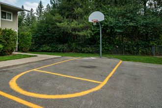 a basketball hoop on a asphalt court in front of a building