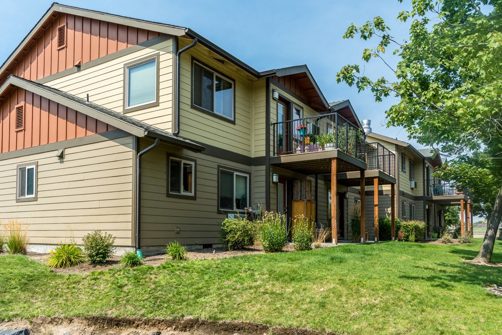 the back of a house with a deck and a yard