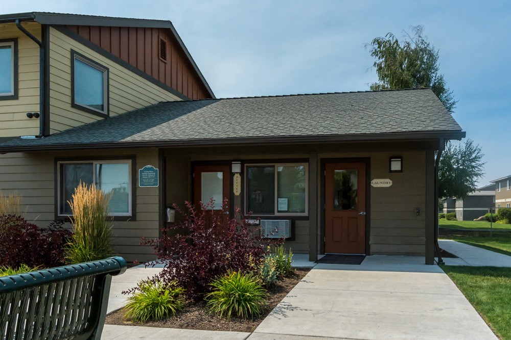 the front of a brown building with a porch and a walkway