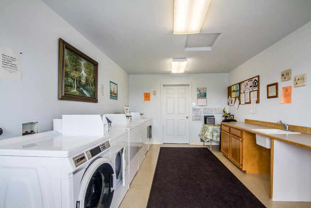 a laundry room with two washing machines and a sink