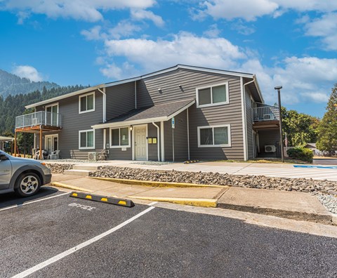 a house with a parking lot and a car parked in front of it