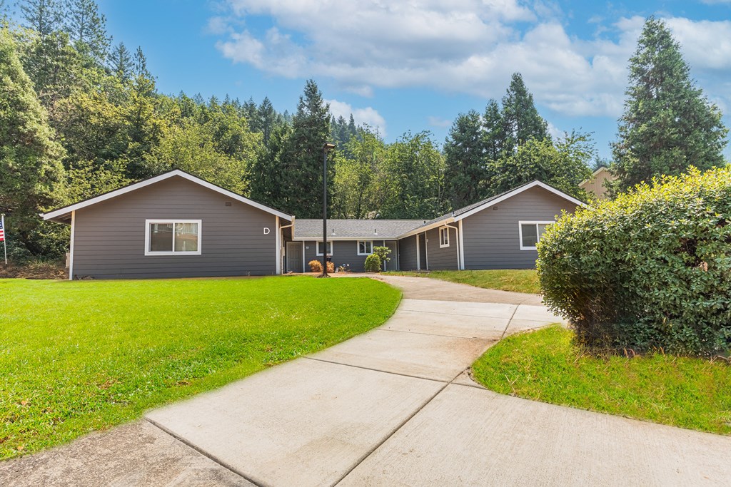 a gray house with a sidewalk in front of it