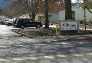 a yellow fire hydrant in front of a village sign