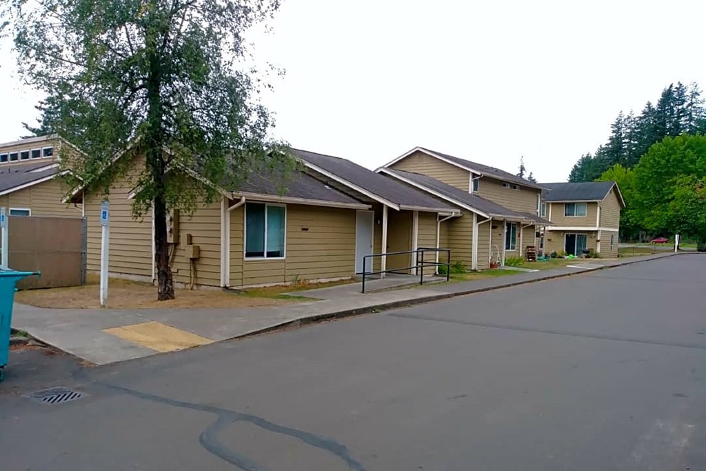a row of houses with a tree in the middle of the road