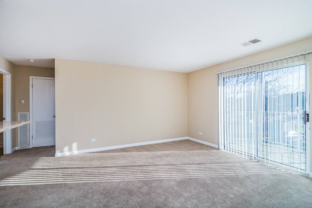 a living room with a large window and a rug