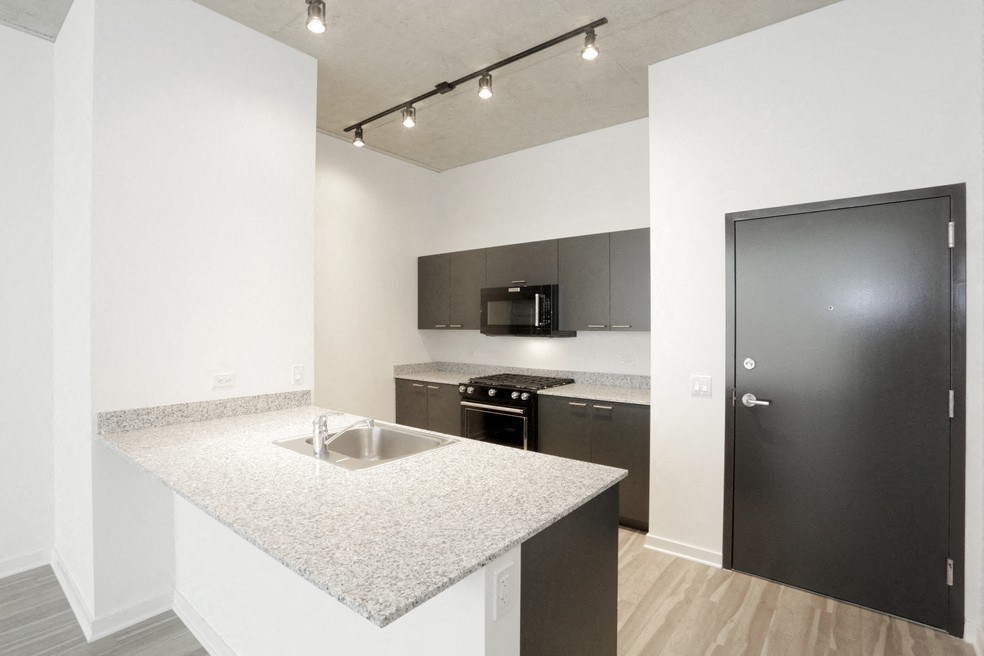 a kitchen with granite counter tops and a black door