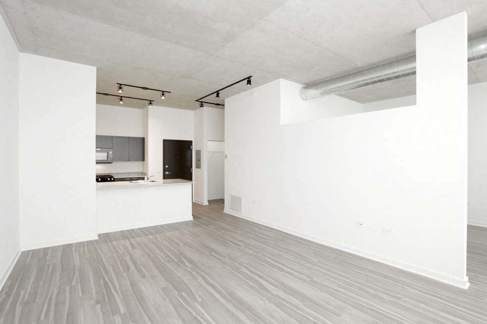 an empty living room with white walls and a wood floor