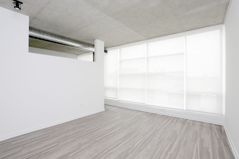 an empty room with a large window and white walls