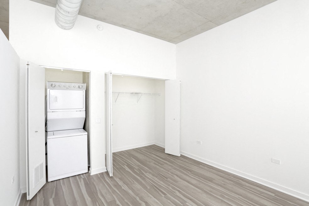 an empty room with a refrigerator and a washer and dryer