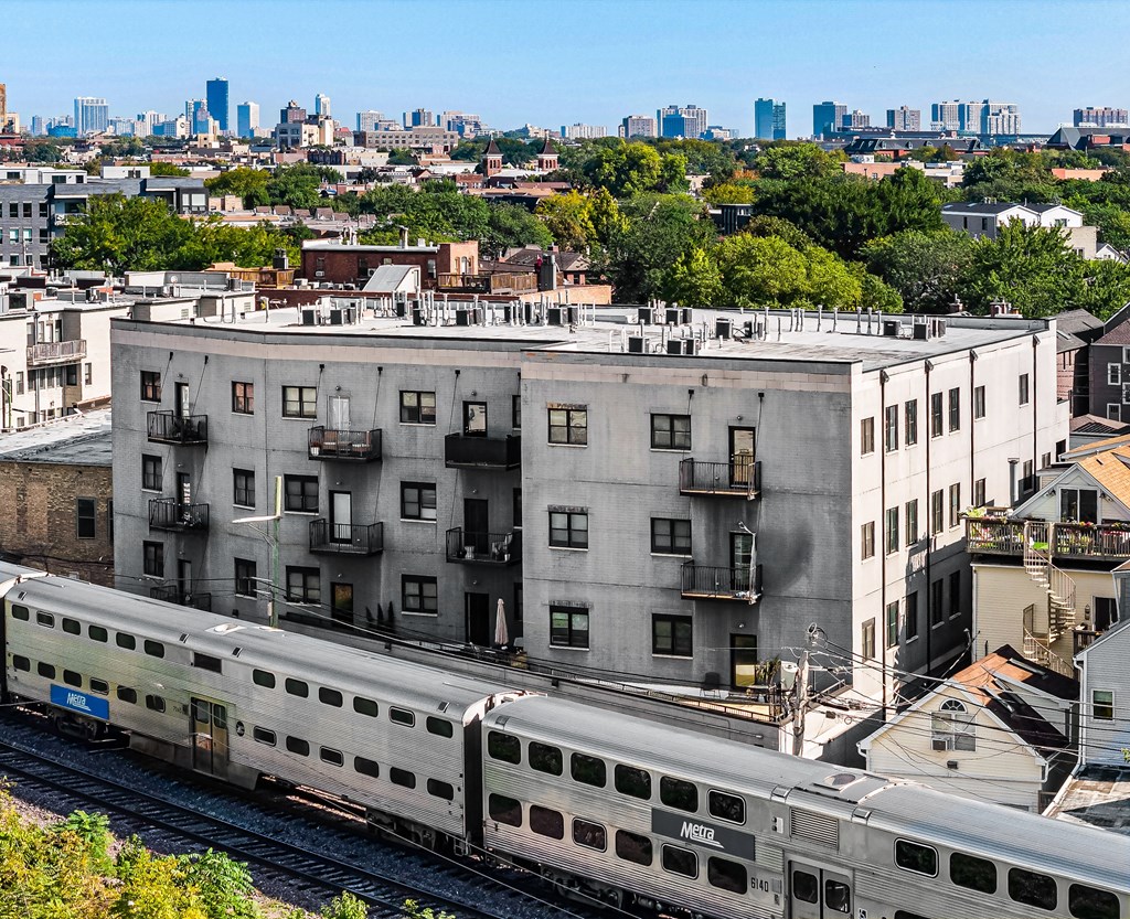 A train is passing by a building.