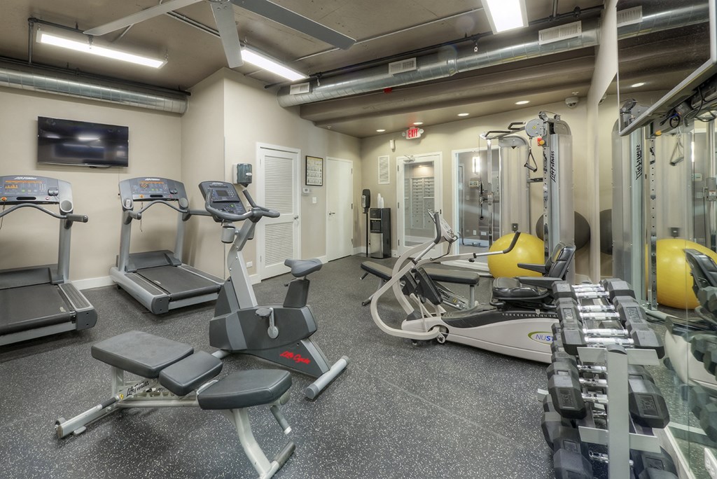 a gym with treadmills and other exercise equipment in a building