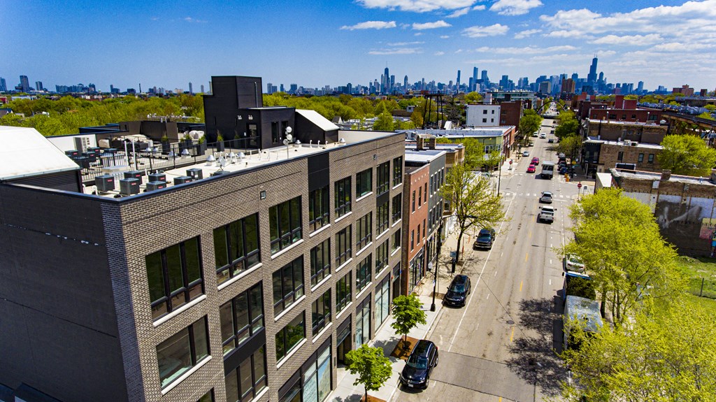 an aerial view of a brick building with the skyline in the background