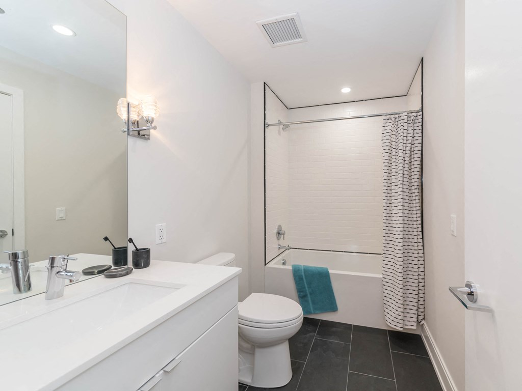 a white bathroom with a shower toilet and sink