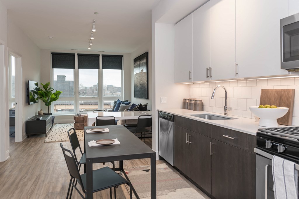 a kitchen and living room in an apartment with a table and chairs