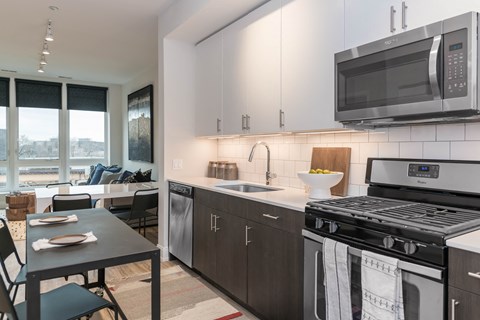 a kitchen with stainless steel appliances and a counter top with a sink and a microwave