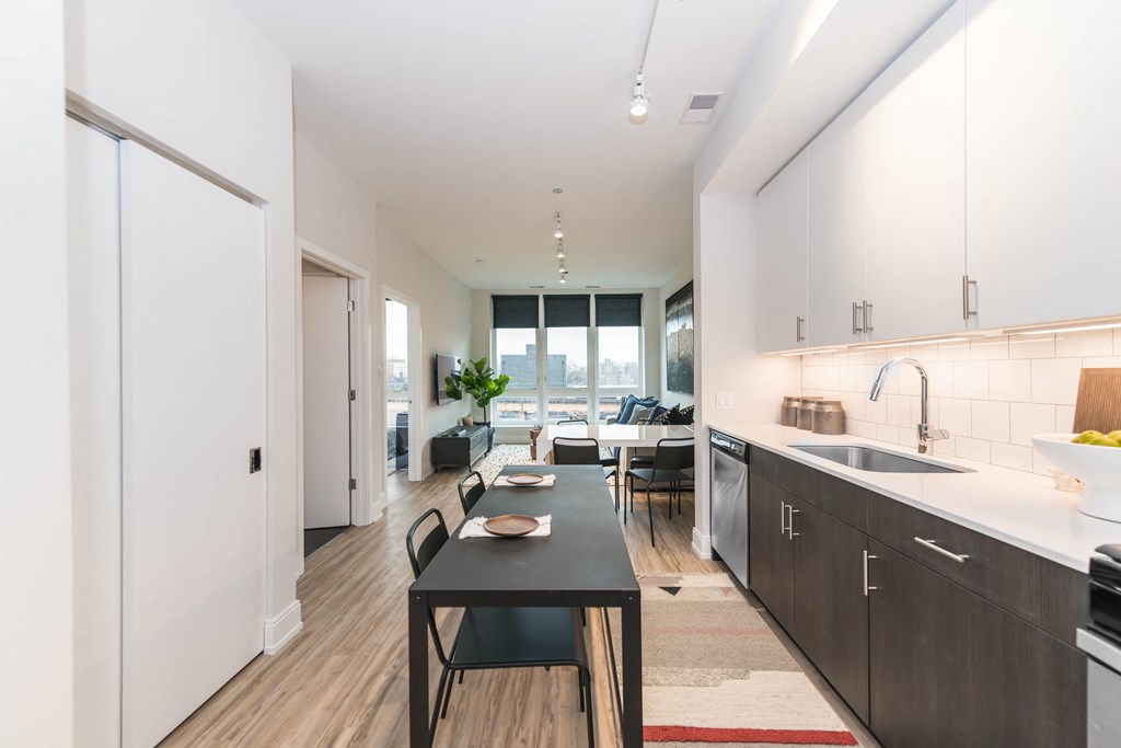 a kitchen and living room with a table and chairs and a large window