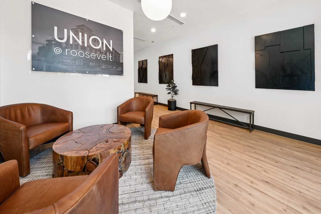 A room with a banner that says "UNION @ ROOSEVELT" and several brown leather chairs and tables.
