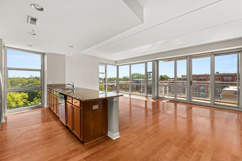 a living room with a large window and a kitchen with a counter top