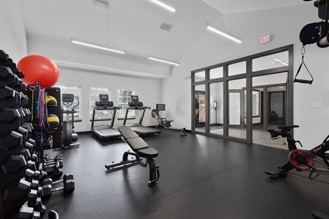 a gym with treadmills and other exercise equipment in a building with glass doors