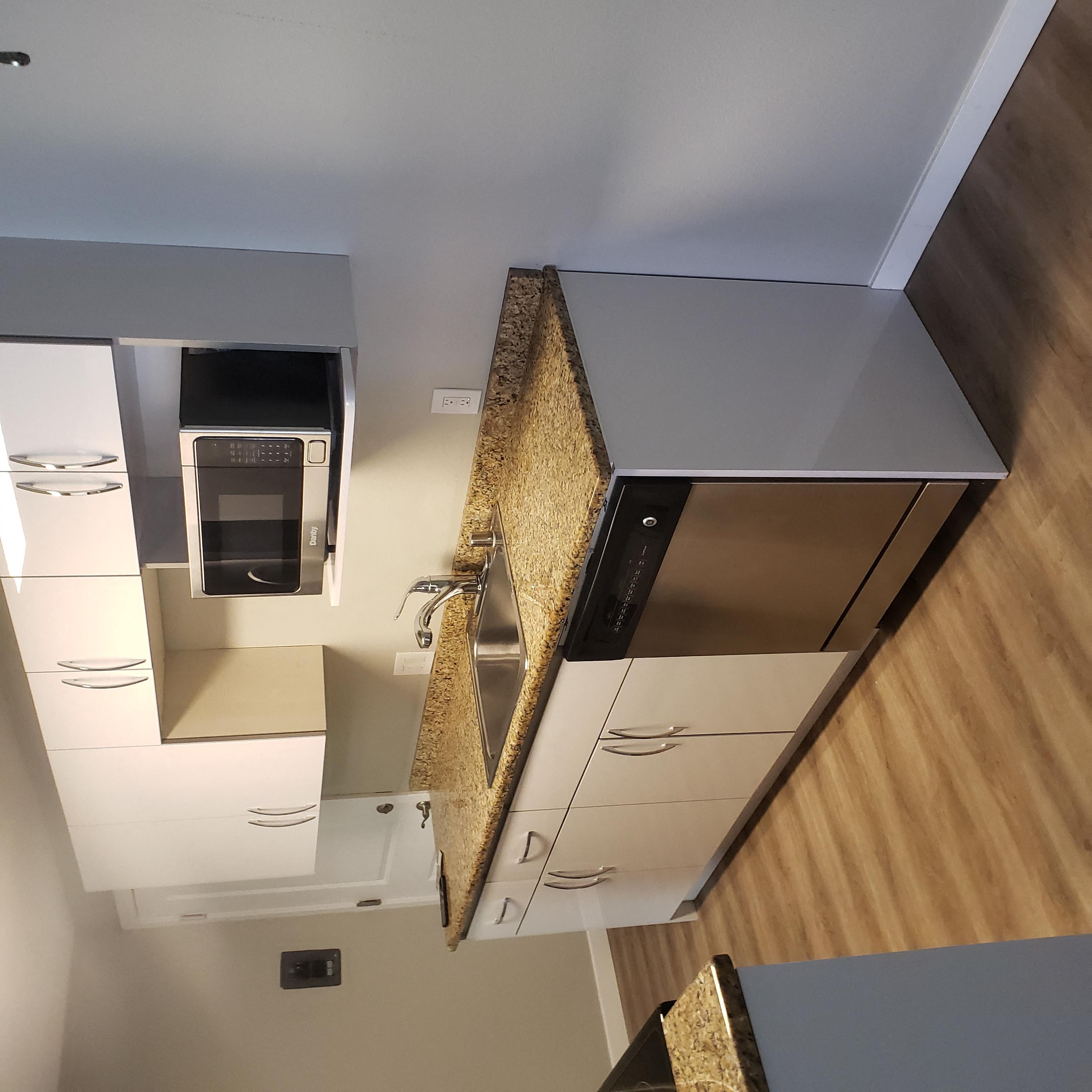 A kitchen with a microwave built into the cabinetry.