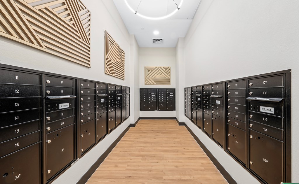 A long hallway with black mailboxes on either side.