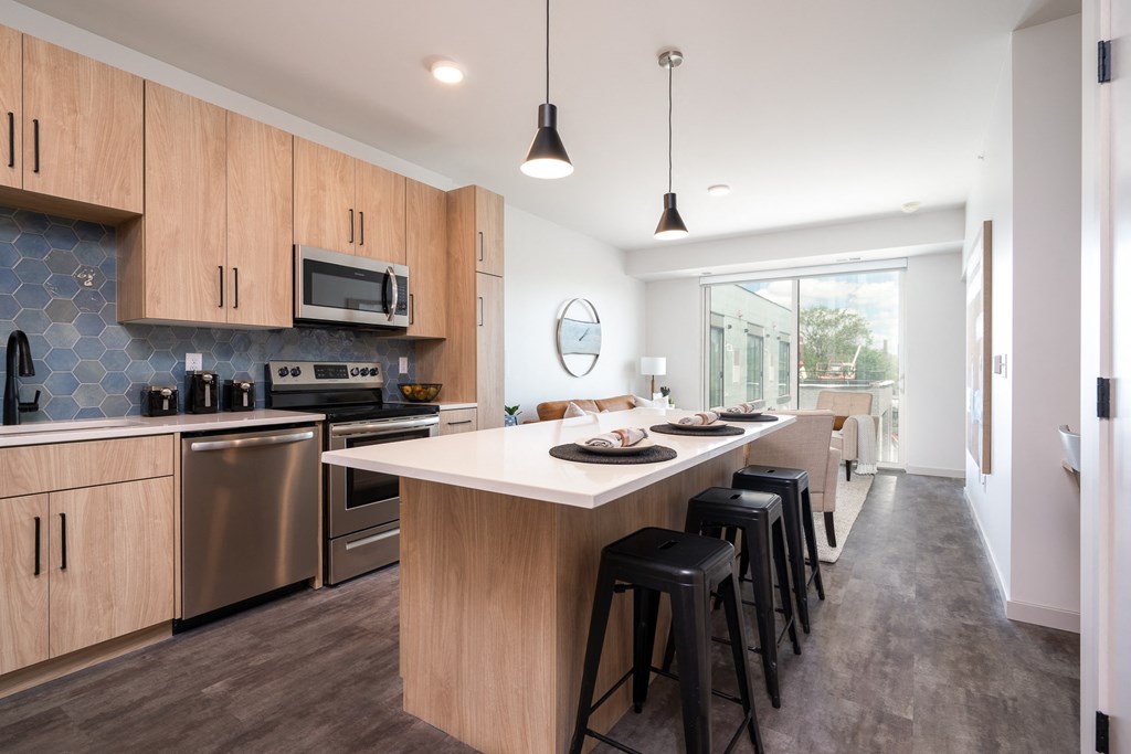 an open kitchen with a large island and stools in front of a dining area