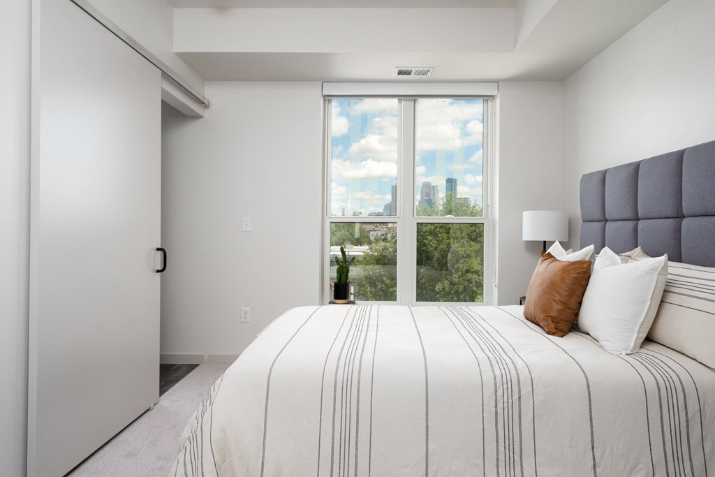 a bedroom with a large bed and a large window