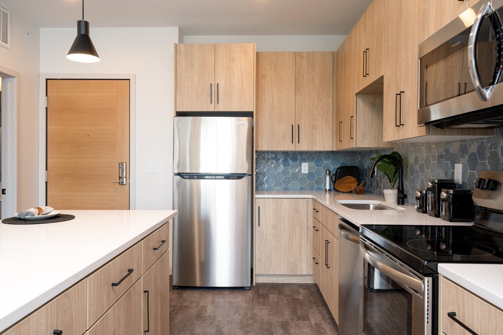 a kitchen with wooden cabinets and a stainless steel refrigerator
