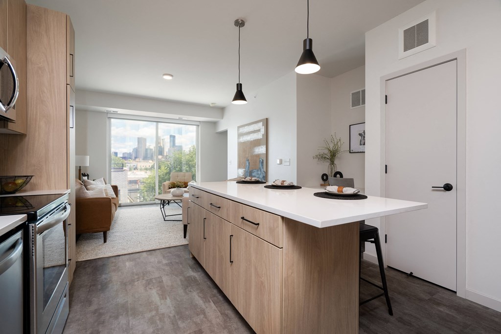 an open kitchen with a large island and a view of a living room