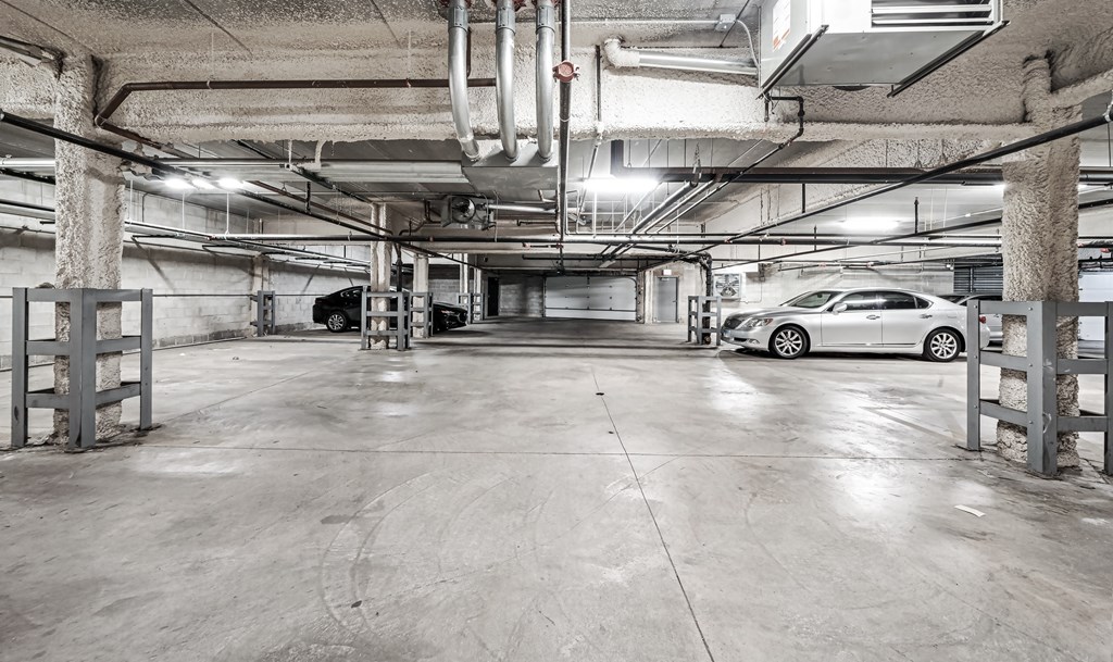 A car is parked in a large, empty parking garage.
