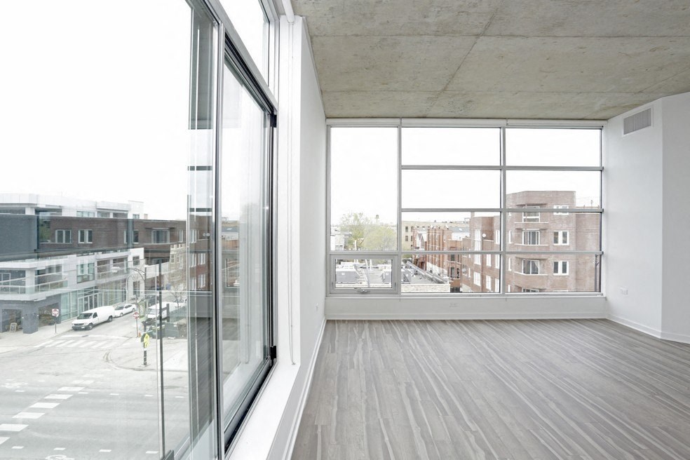 a living room with a large window and wooden floors