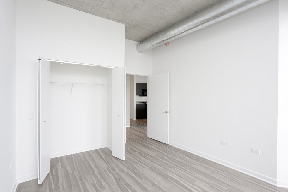 an empty room with white walls and a door to a closet