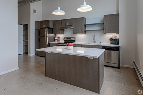 A modern kitchen with a center island and stainless steel appliances.