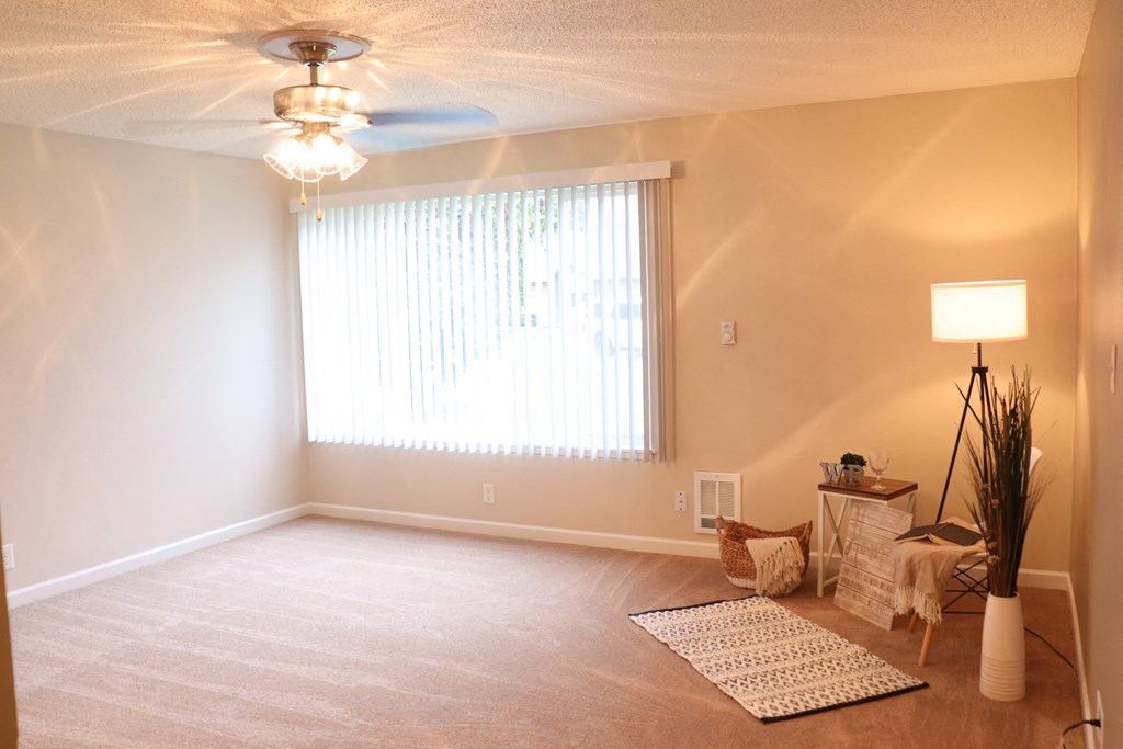 a living room with a ceiling fan and a window