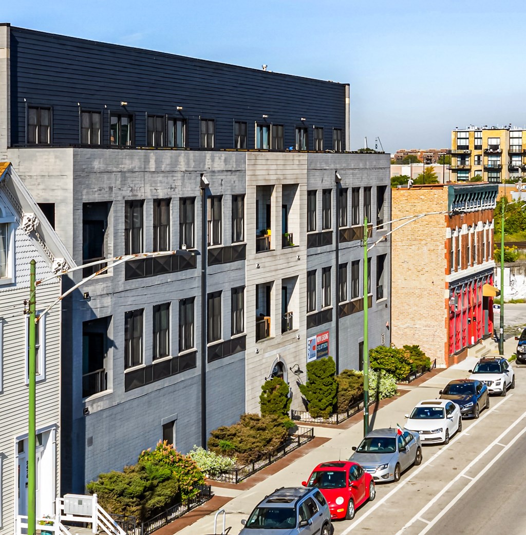 A street view of a city with cars parked on the side of the road.