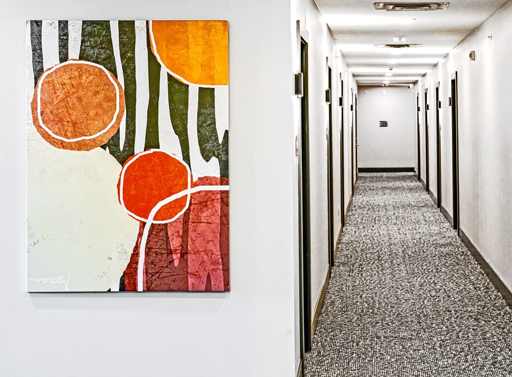 two paintings hanging on a hallway wall in a building