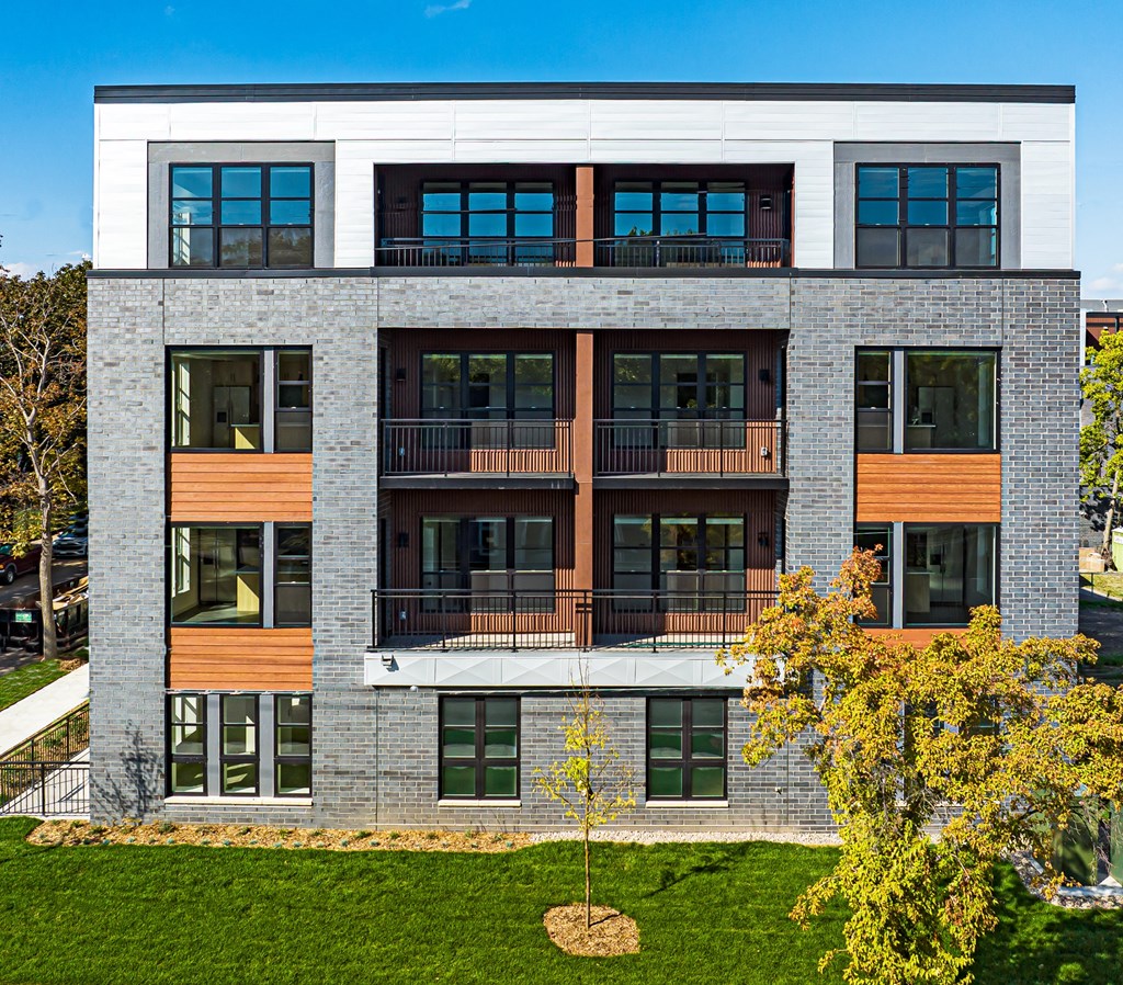 the exterior of a building with green grass and trees