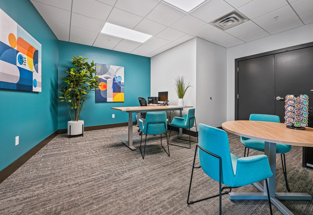 an open office space with tables and chairs and a blue wall