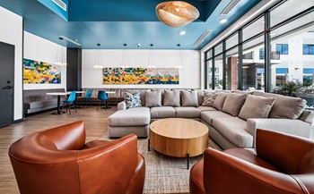A living room with a brown leather chair and a grey sofa.