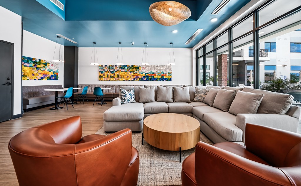 A living room with a brown leather chair and a grey sofa.